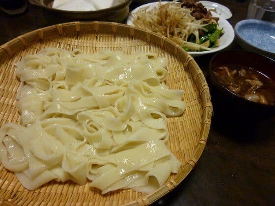 대나무 쟁반 위에 쌓인 중간 폭의 납작한 히모카와 면