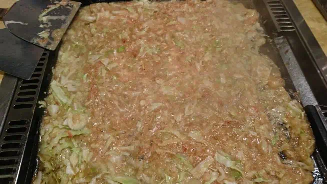 Kubis dan topping yang sedang dimasak di plat monjayaki