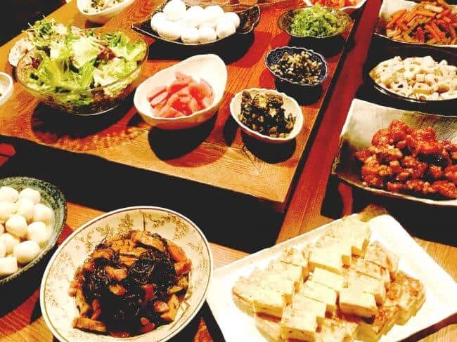 Assorted Japanese dishes, including salads, tofu, and pickled vegetables on traditional tableware.