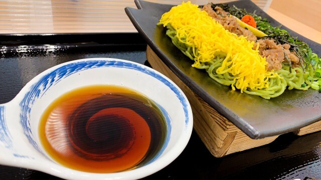 Bol de sauce tsuyu chaude à côté d'une kawara soba sur une tuile