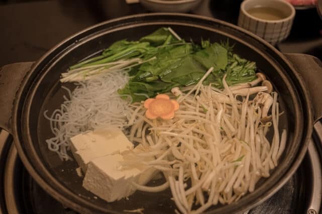 두부, 숙주, 팽이버섯, 푸른 채소, 당면을 담아 샤브샤브를 준비한 냄비