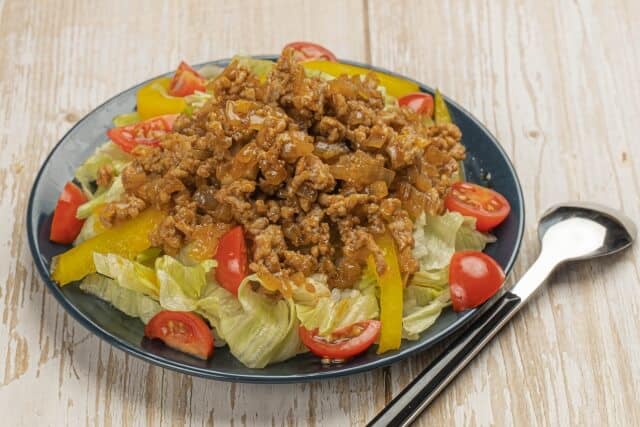 taco rice in black plate with spoon beside