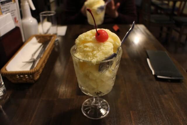 Nagasaki Milk Shake on wooden table and condiments on side