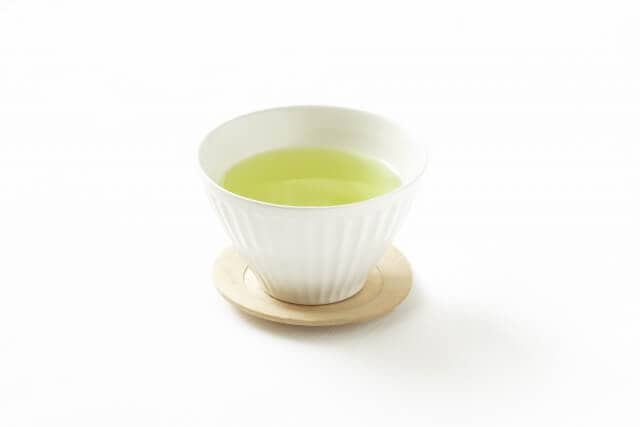 Ryokucha on white cup with wooden saucer