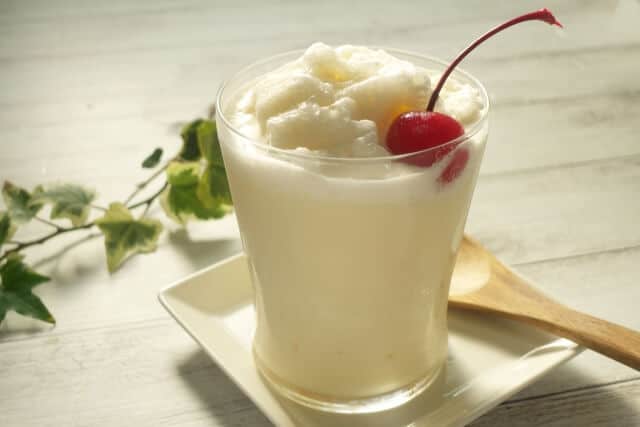 Nagasaki Milk Shake with cherry toppings and wooden spoon beside it