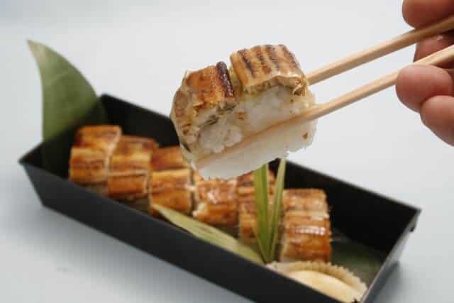 anago zushi being held by chopsticks