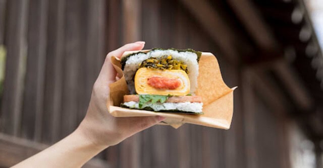 Pork tamago onigiri being held