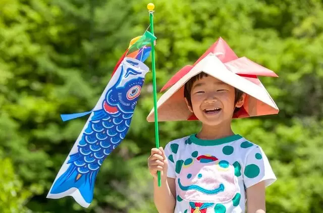 children smiling holding a fish like balloon