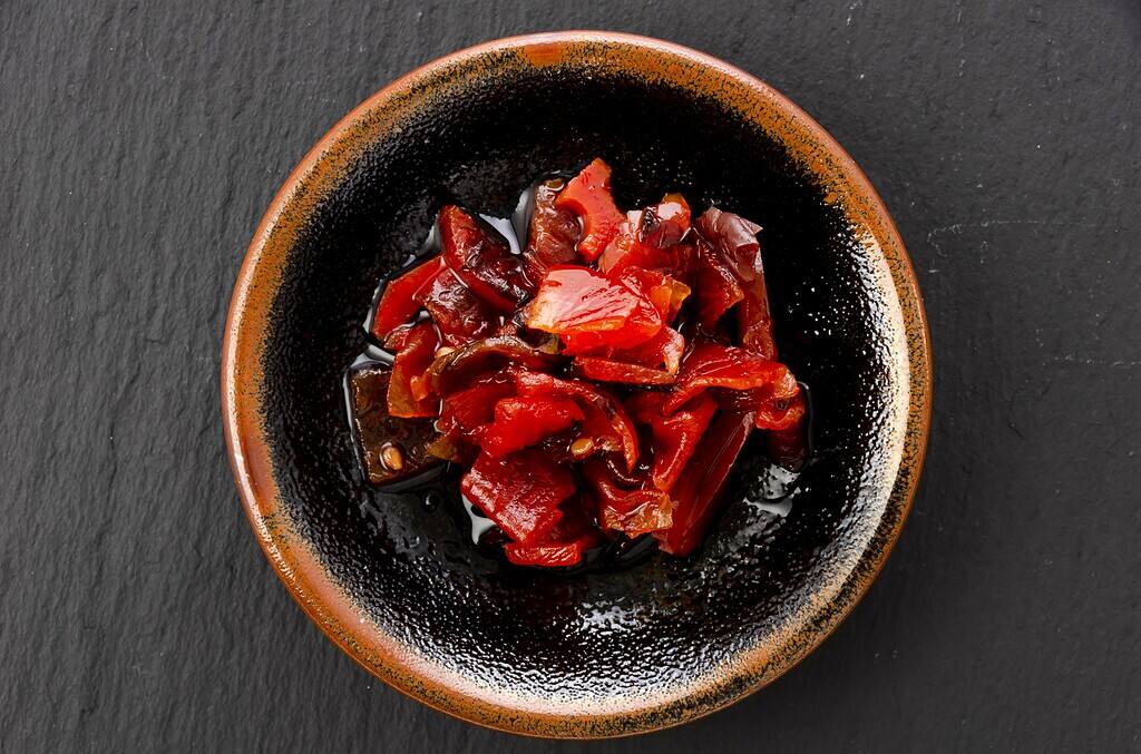 Spicy Japanese pickled vegetables in a rustic black bowl, traditional Japanese food presentation.