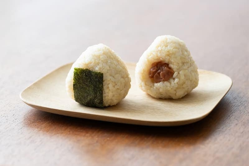 Steamed onigiri rice balls with seaweed and filling, traditional Japanese snack and comfort food.