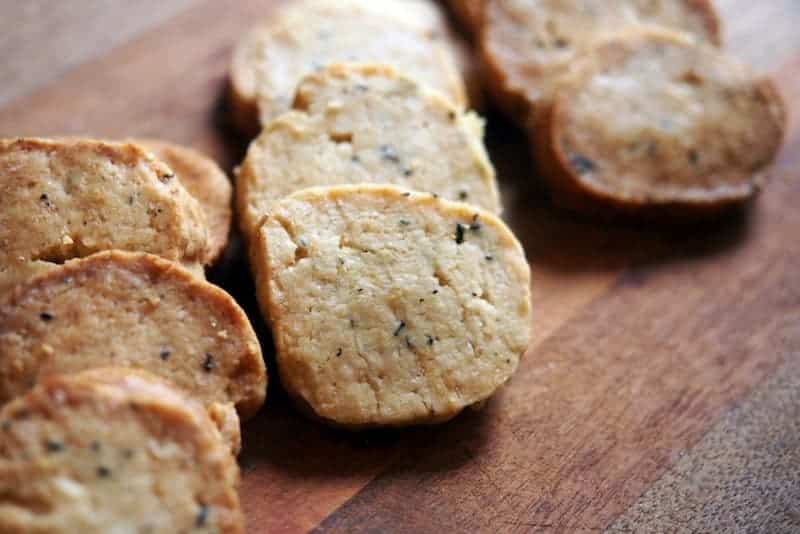 Soft tofu cookies with black sesame seeds on a wooden surface.