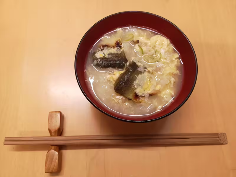 ayu zousui on a bowl with chopsticks placed below it