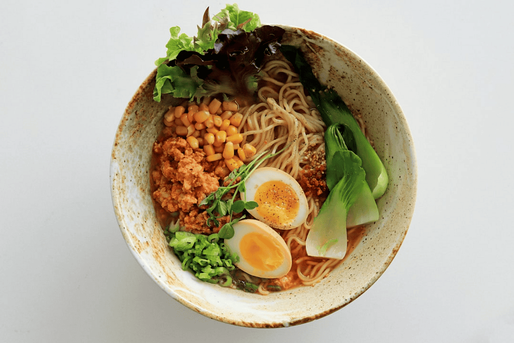 Savory Japanese ramen bowl with soft-boiled eggs, vegetables, and broth for authentic Japanese cuisine experience.