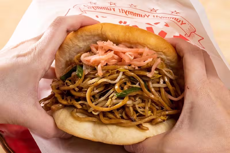 Yakisoba bread with hands holding it