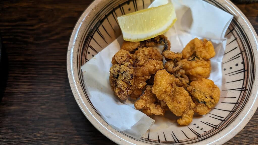 Crispy Japanese fried calamari with lemon wedge, authentic seafood dish in Japan.