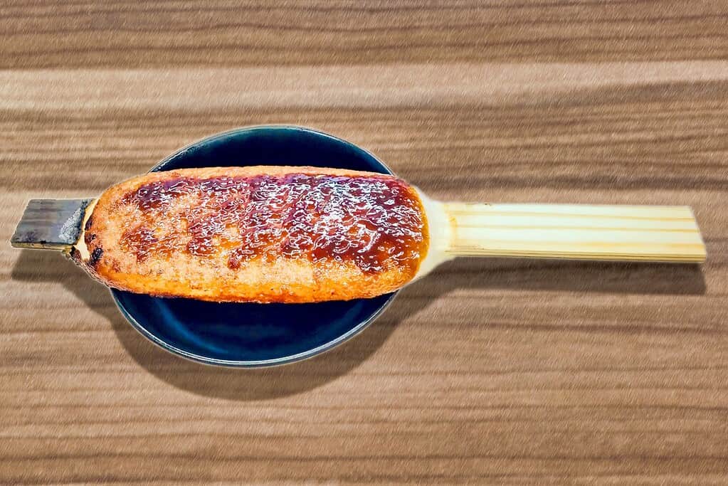 A close-up of a savory misokatsu skewer with rich miso sauce, served on a dark plate for authentic Japanese flavor.