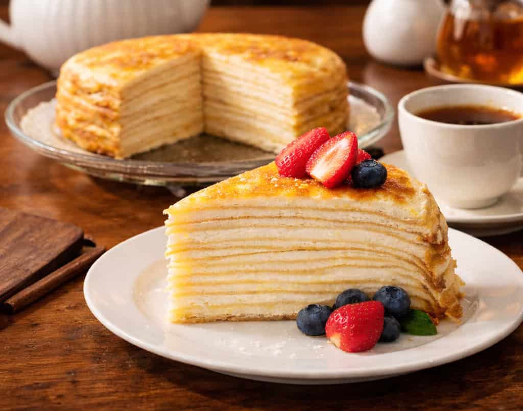 Delicious Mille Crepes with fresh berries served in a Japanese cafe setting.