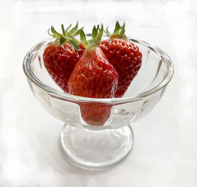 Fresh strawberries in a glass bowl, showcasing Japanese fruit quality.