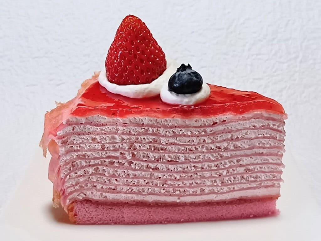Delicious Mille Crepes cake topped with strawberry and blueberry, showcasing Japan's popular cafe de.