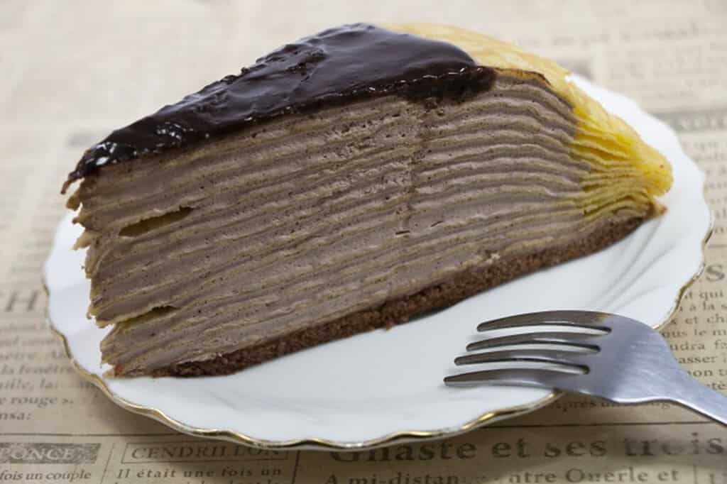 Mille Crepes cake with multiple thin layers and chocolate topping.