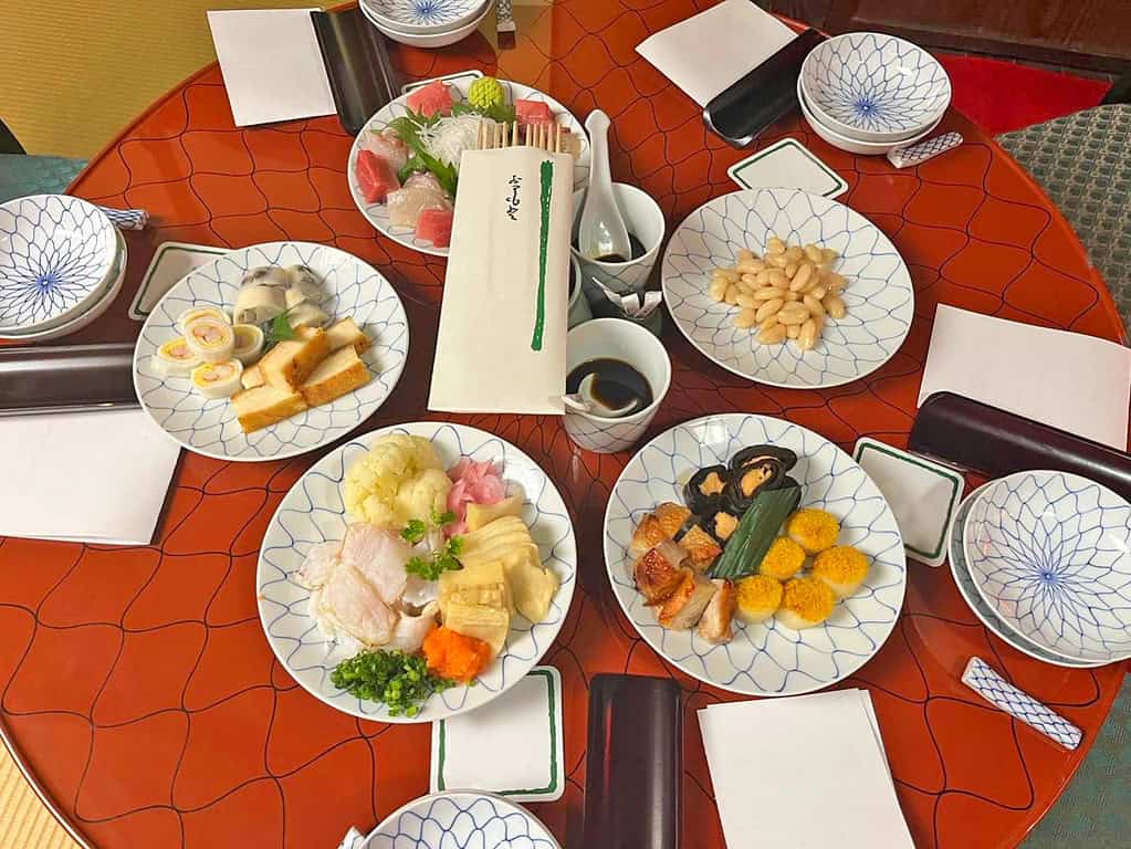 Delicious Japanese seafood platter featuring sashimi, roe, and vegetables in a refined restaurant setting.