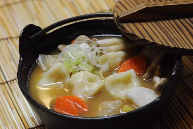 Otsuke Dango ingredients including daikon, burdock, carrot, taro, and miso broth