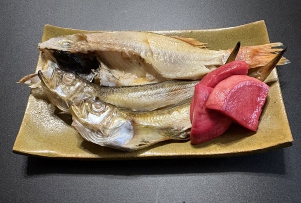 Grilled Nodoguro fish with pickled radish on a ceramic plate in Japan.