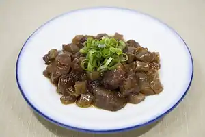 Traditional Kobe Bokkake beef stew with green onions on a white plate.