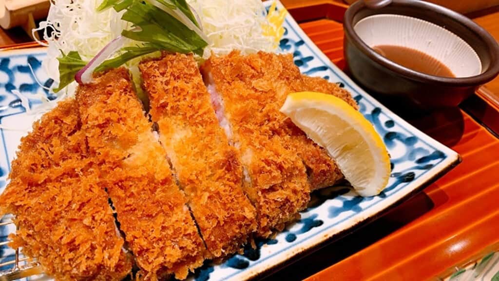 Crispy Kagoshima black pork tonkatsu with lemon and dipping sauce.