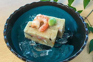 Traditional Japanese Igisu Tofu with shrimp and green pea on blue plate.