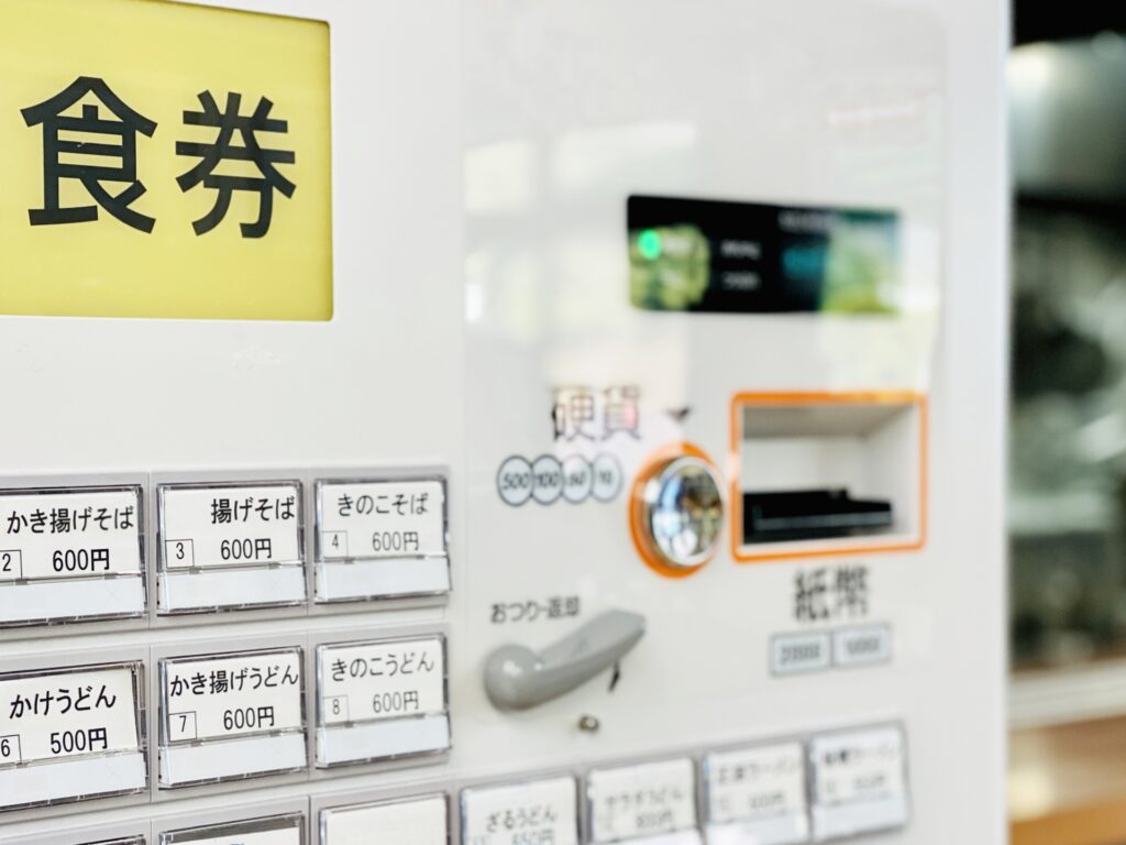 Japanese vending machine selling meal tickets for affordable food options.