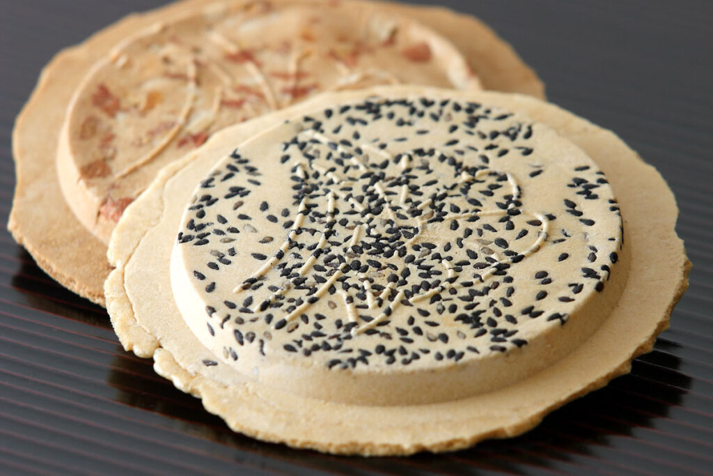 Traditional Japanese rice crackers with black sesame seeds and soy sauce flavor.