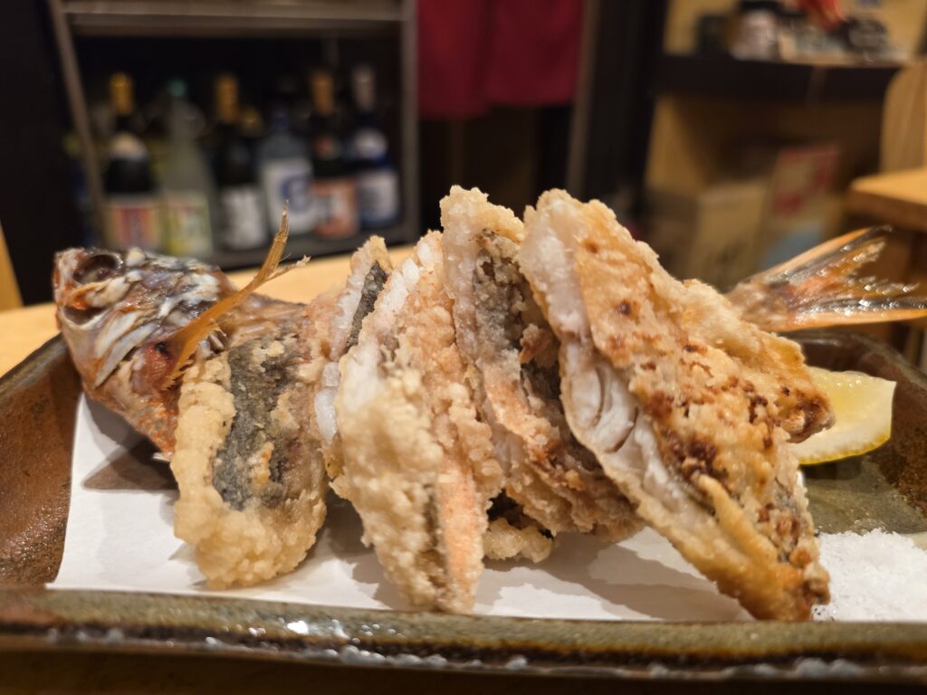 Crispy fried gurukun fish served with lemon in Japan.