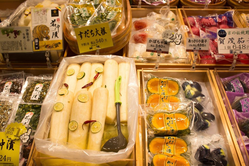 Traditional Japanese pickled vegetables and preserved foods in a market display.