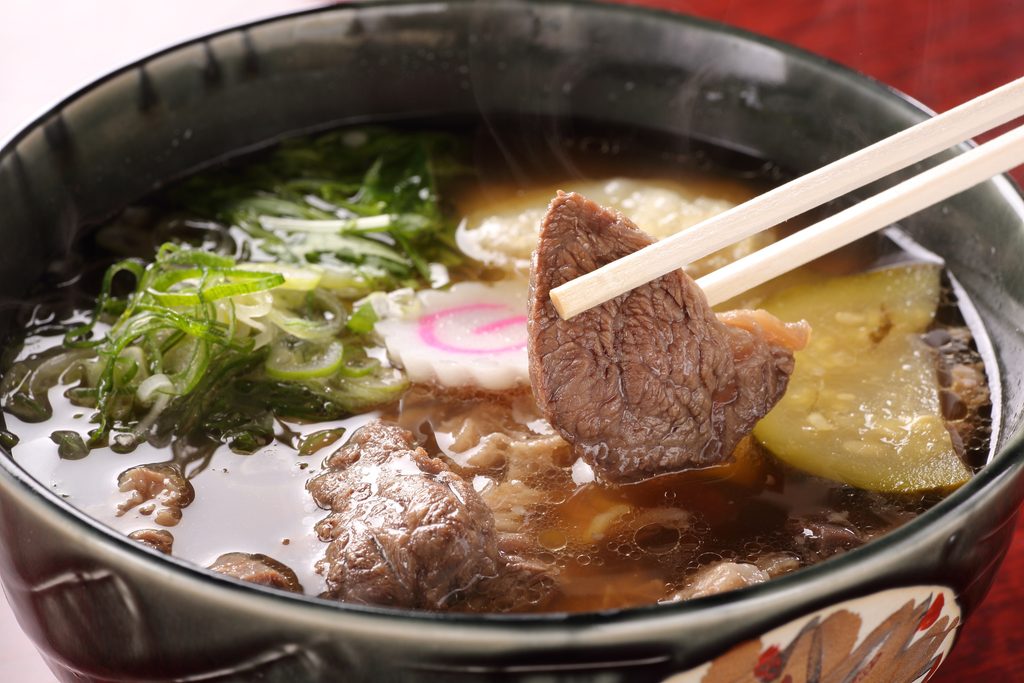 Obanazawa Beef Ramen with beef, green onions, and vegetables in a black bowl.