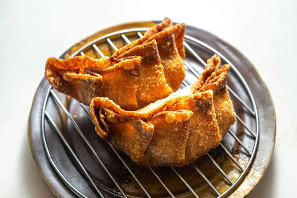 Crispy fried gyoza dumplings on a wire rack in Japan.