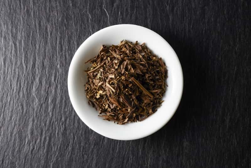 Close-up of roasted Karigane Hōjicha tea leaves in a white bowl.