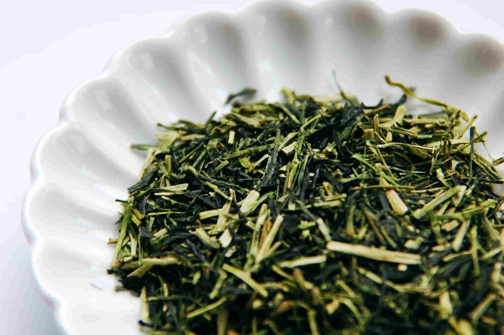 Karigane tea from Uji, a mix of pale green tea stems and dark green leaf pieces in a white dish