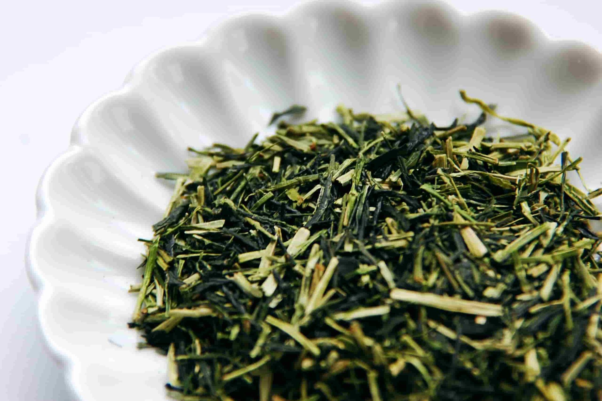 Karigane tea from Uji, a mix of pale green tea stems and dark green leaf pieces in a white dish