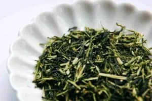 Karigane tea from Uji, a mix of pale green tea stems and dark green leaf pieces in a white dish